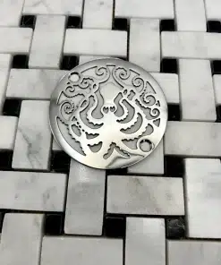 Round drain with octopus design in polished stainless steel finish.