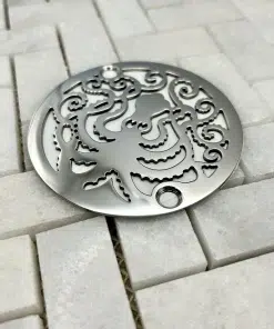 Round drain with octopus design in polished stainless steel finish.