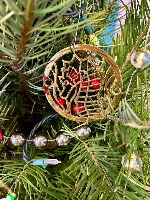 Seahorse round drain in polished brass finish.