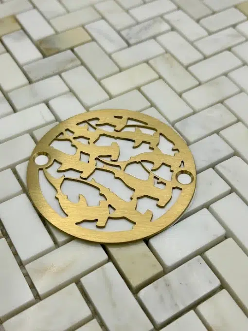 Round drain in a brushed brass finish.