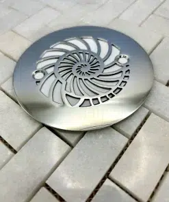 Round drain with nautilus design in polished stainless steel finish.