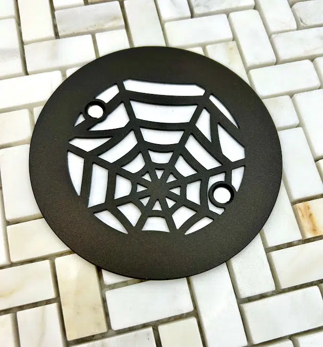 4.25 round spider web oil rubbed bronze on off white tile