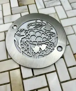 4in round Turtle design in Brushed Stainless Steel off white tile