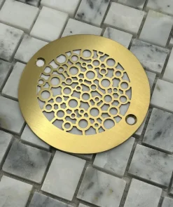 Round drain in a brushed brass finish.