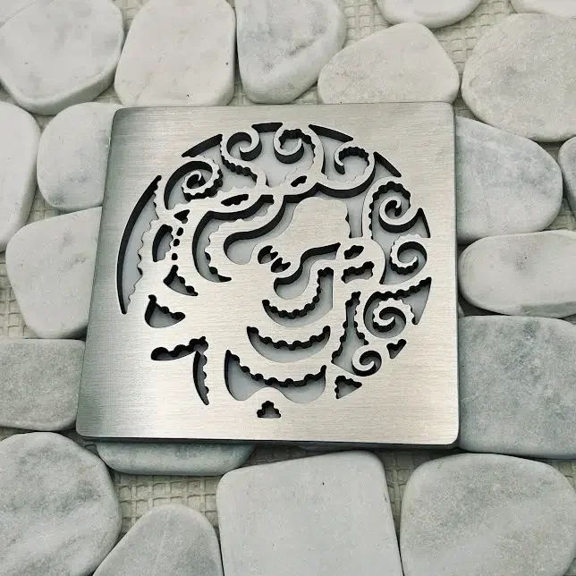 Square shower drain with brushed stainless steel finish.