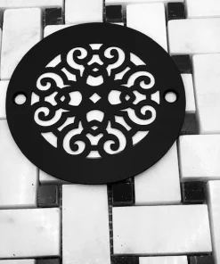 Scrolls No. 4, 4 inch round shower drain with matt black finish on black and white tile.