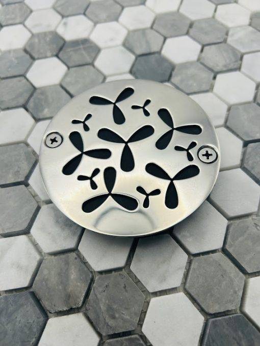 Round drain with polished stainless steel finish.