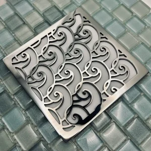 Square shower drain with waves design. Polished stainless steel finish.