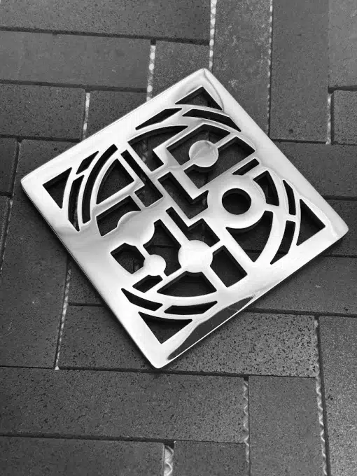 Square shower drain with art history design, polished stainless steel