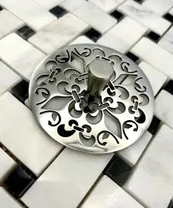 Round sink strainer with fleur de lis design in polished stainless steel finish.