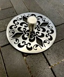 Round sink strainer with fleur de lis design in polished stainless steel finish.