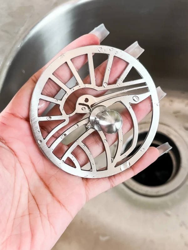 round polished stainless steel sink strainer with pelican shaped cut out design
