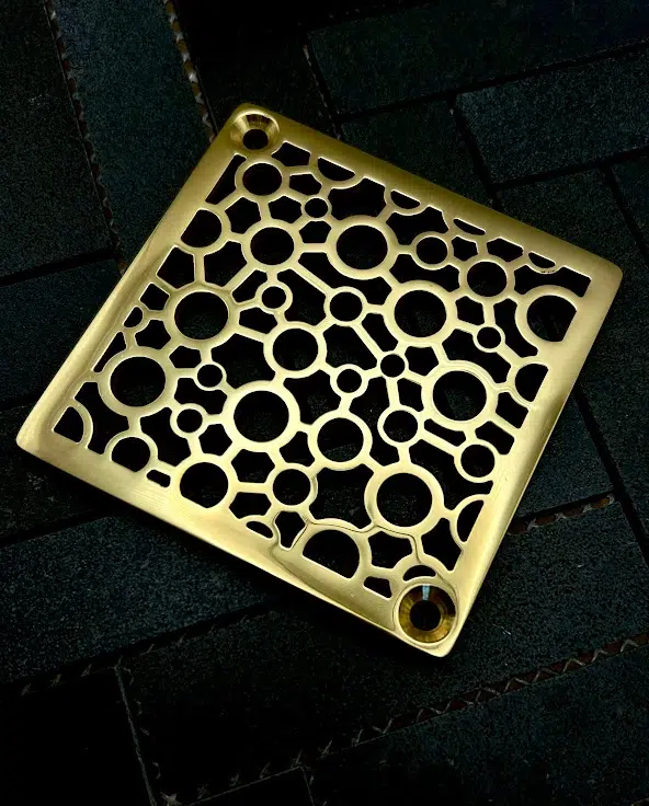 Square drain with polished brass finish.