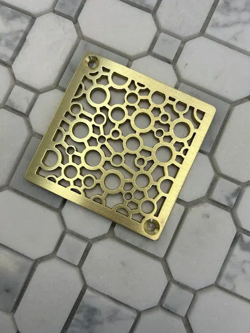 Square drain with unlaquered brushed brass finish.