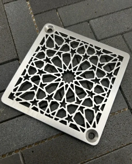 Square drain with a brushed brass finish.