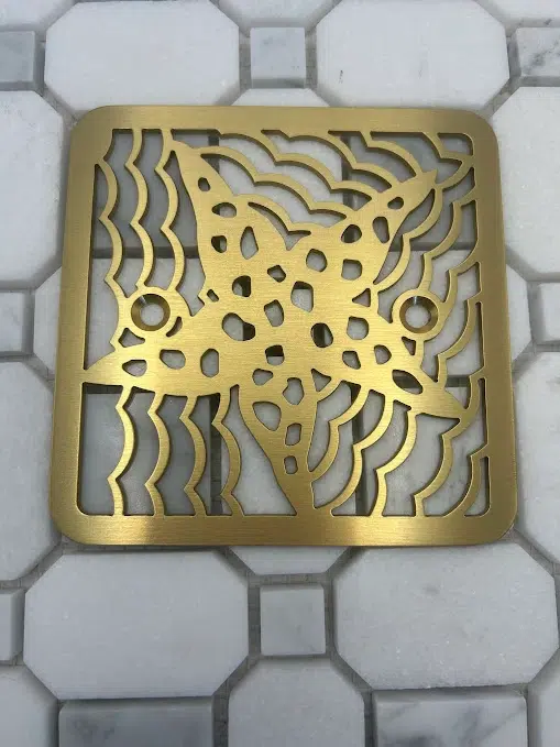 Square drain in brushed brass finish.