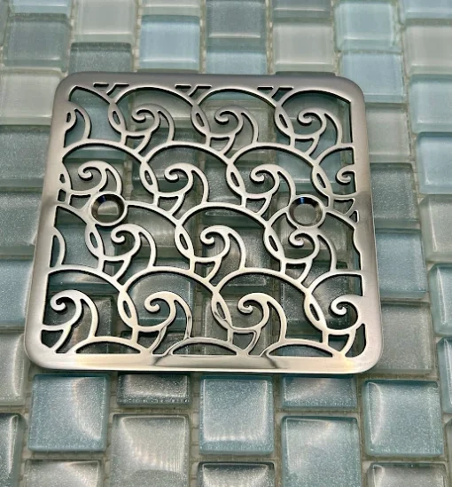 Square drain with polished stainless steel finish.