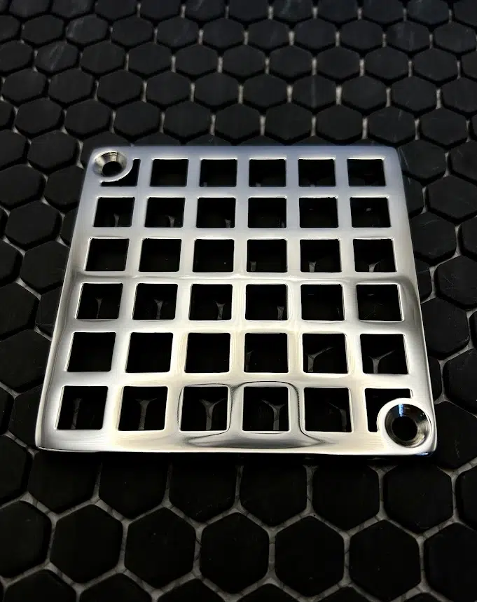 Square drain with Geometric squares 7 design in polished stainless steel finish.