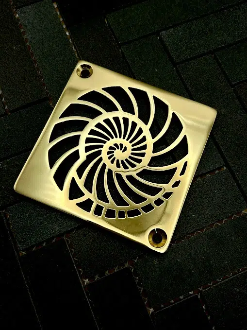 Square drain with polished brass finish.