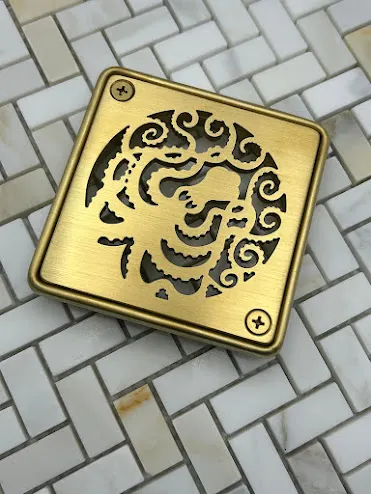 Square drain with brushed brass finish.