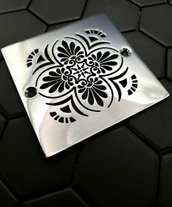 Square drain with greek anthemion design in polished stainless steel finish.