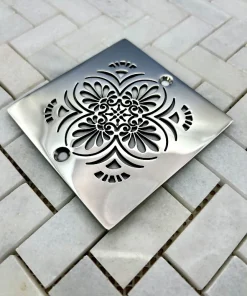 Square drain with greek anthemion design in polished stainless steel finish.