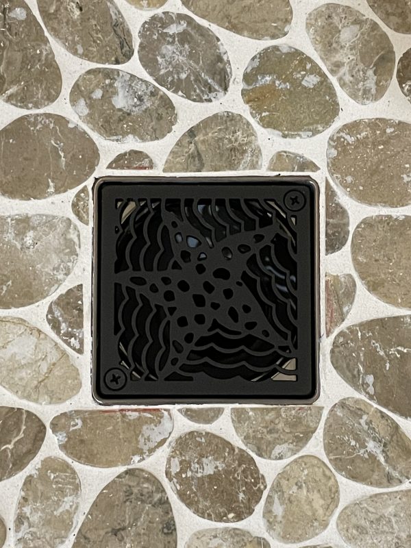 starfish square shower drain on rock tile floor