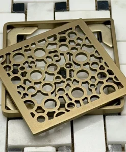 Nature Bubbles square Wedi replacement kit in Champagne Bronze on black and white tile.