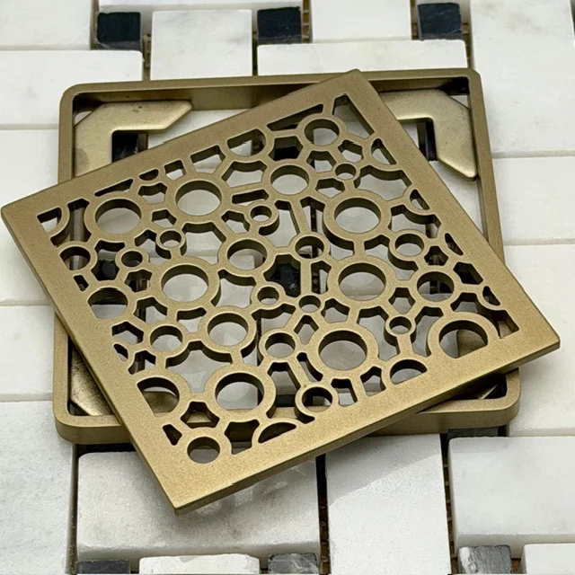 Nature Bubbles square Wedi replacement kit in Champagne Bronze on black and white tile.