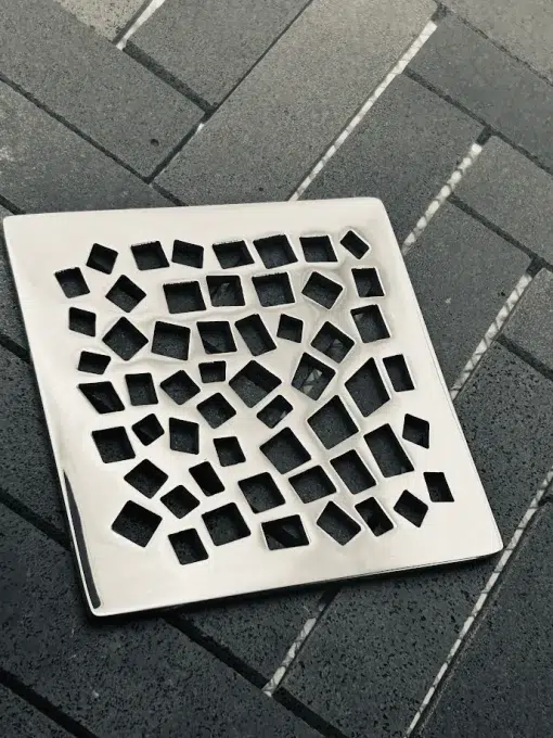 Square shower drain with polished stainless steel finish.