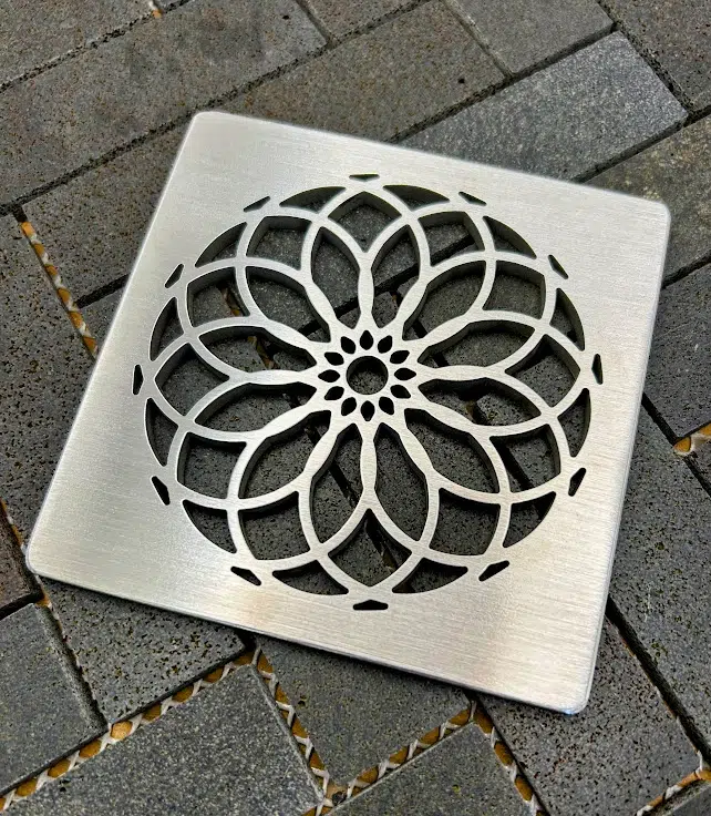 Square drain with a brushed stainless steel finish.