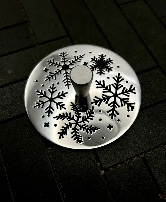 Round sink strainer with polished stainless steel finish.