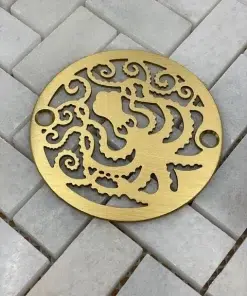 Octopus 3.25 round shower drain brushed brass on white tile