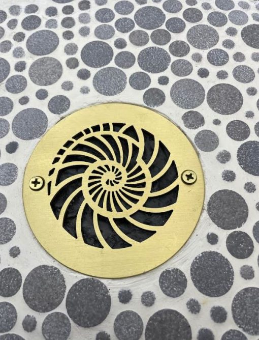 Nautilus Design 4 inch Round Brushed Brass on tile Designer Drains.