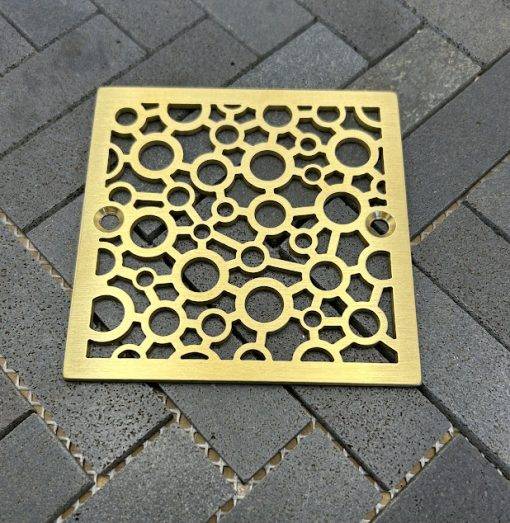 Square drains with brushed brass finish.