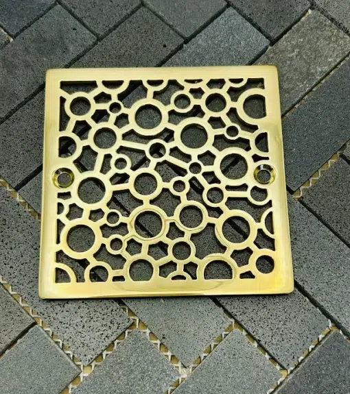 Square drain with polished brass finish.