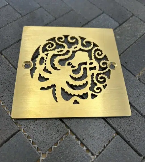 Square drain with brushed brass finish.