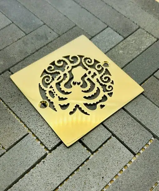 Square drain with polished brass finish.