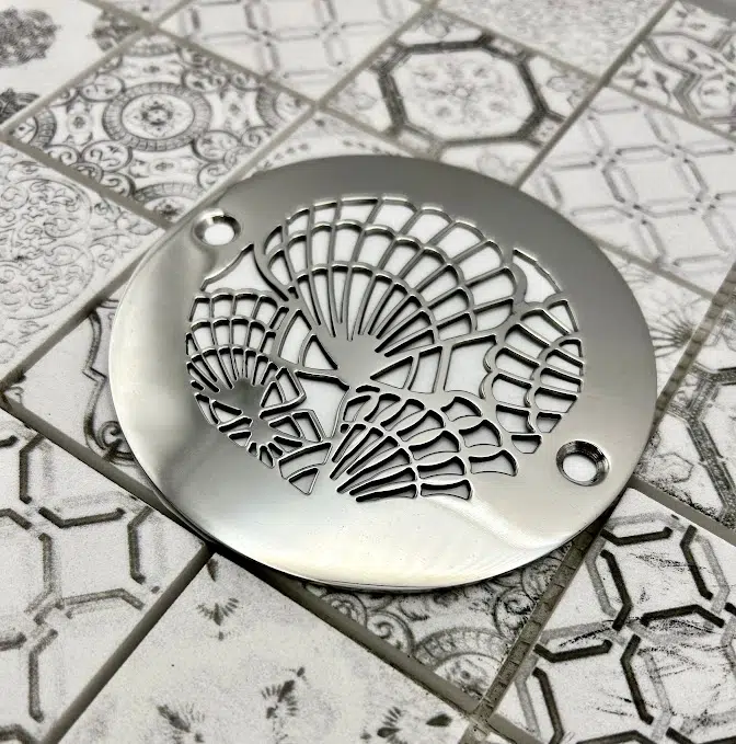 Round drain in polished stainless steel finish.