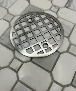 Round drain in polished stainless steel finish.