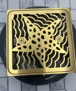 Square drain in brushed brass finish with drain body rough in.