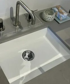 Round sink stopper with polished stainless steel finish.