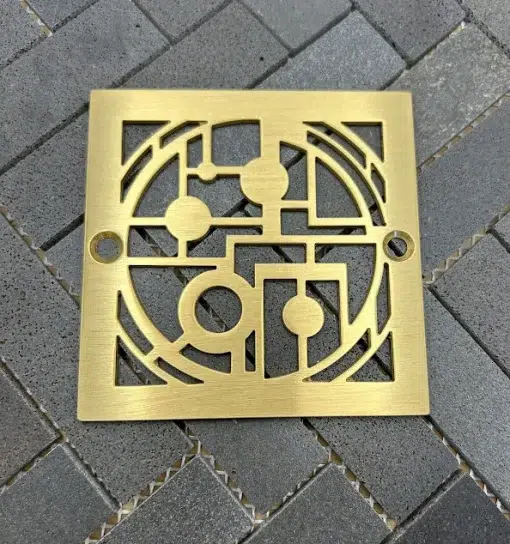 Square drain with brushed brass finish.
