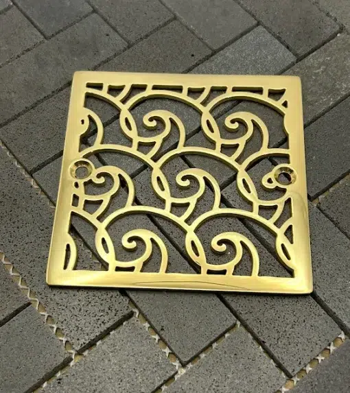 Square drain with polished brass finish.