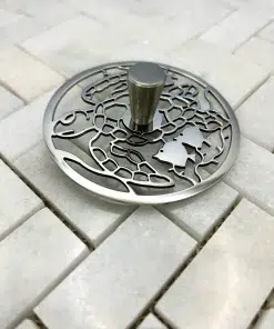 Round sink strain with turtle design in polished stainless steel finish.