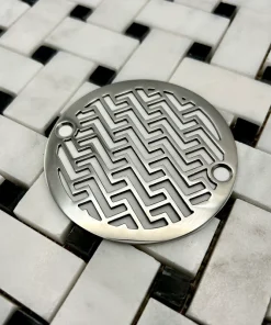 Round drain in polished stainless steel finish.