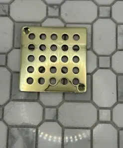 Square drain with geometric circle design in unlacquered polished brass finish.