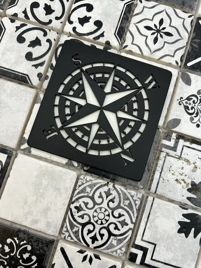 compass rose design in matte black finish on black decor tile