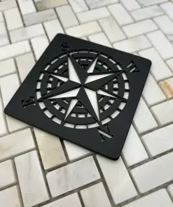 compass rose design in matte black finish on off white tile