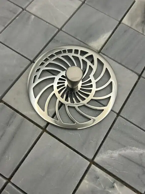 Nautilus Kitchen Sink Strainer polished stainless steel on gray tile